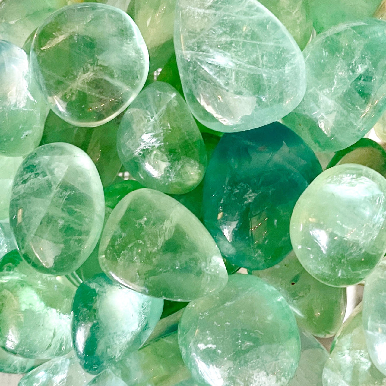 Polished green fluorite assorted tumbled crystals with translucent and transparent qualities