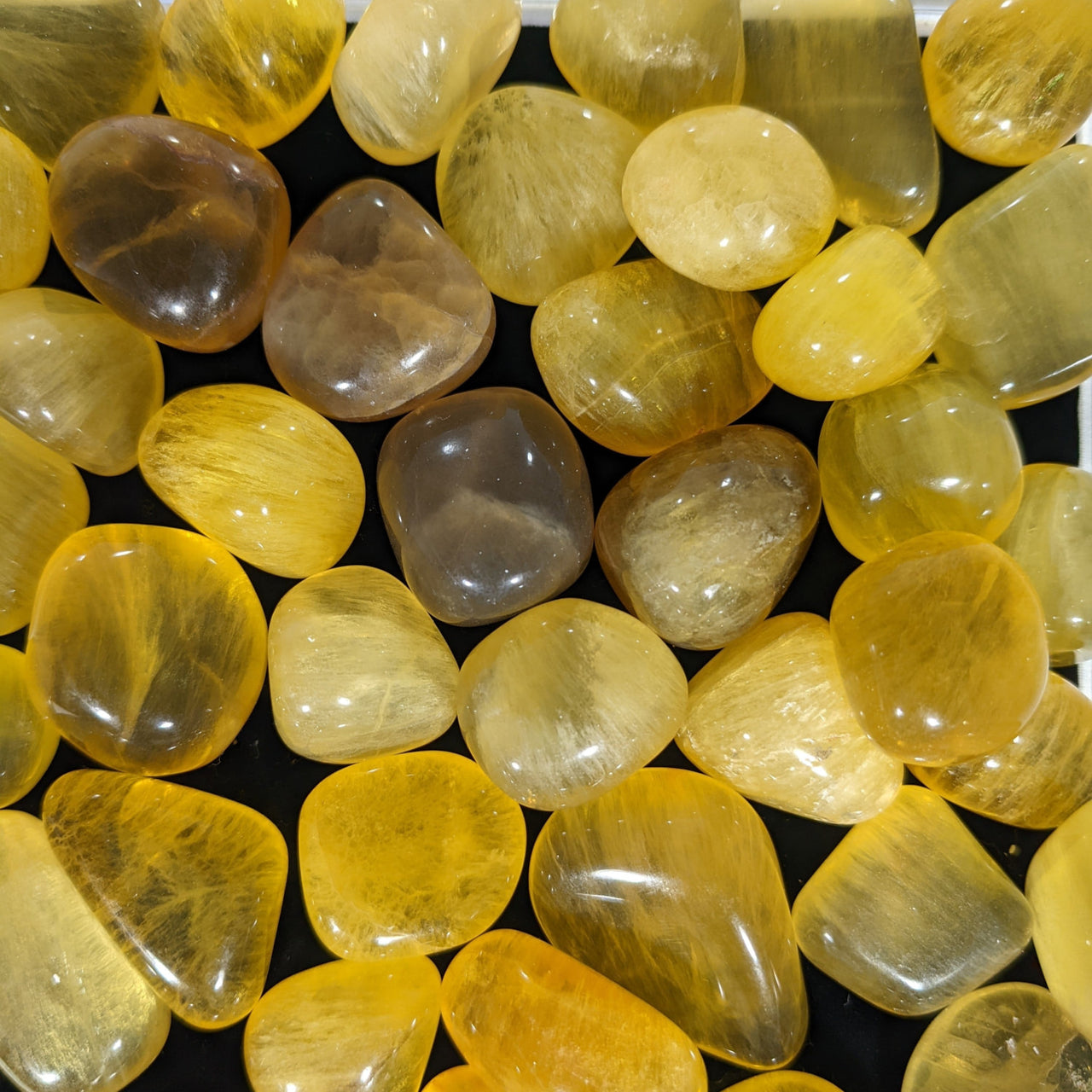 Polished yellow and smoky quartz stones in Fluorite Assorted Tumbled collection