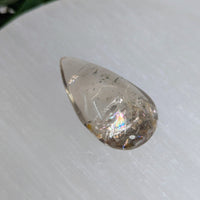 A 1.6 inch polished teardrop garden quartz pendant with clear quartz natural inclusions and subtle rainbow sheen