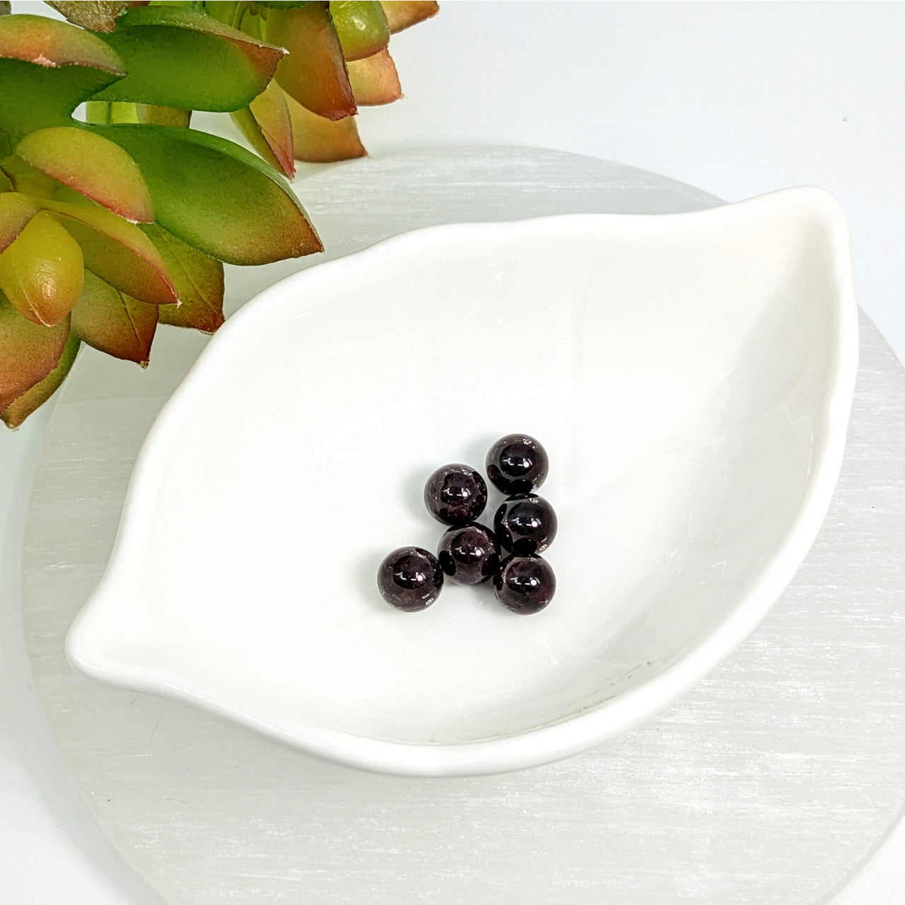 White leaf-shaped ceramic dish with Garnet 7.5mm round beads for jewelry making