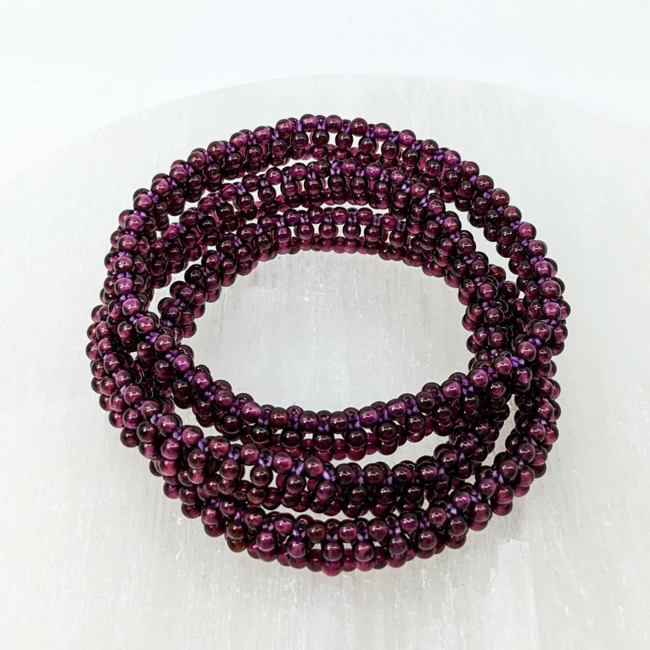 Purple glass beads stack displayed in Garnet Beaded 7’ Woven Bracelet #LV2439