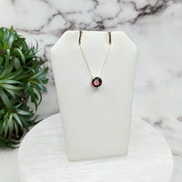 Thumbnail for Close-up of Garnet Faceted Necklace with Sterling Silver Slider Pendant on Display with Plant