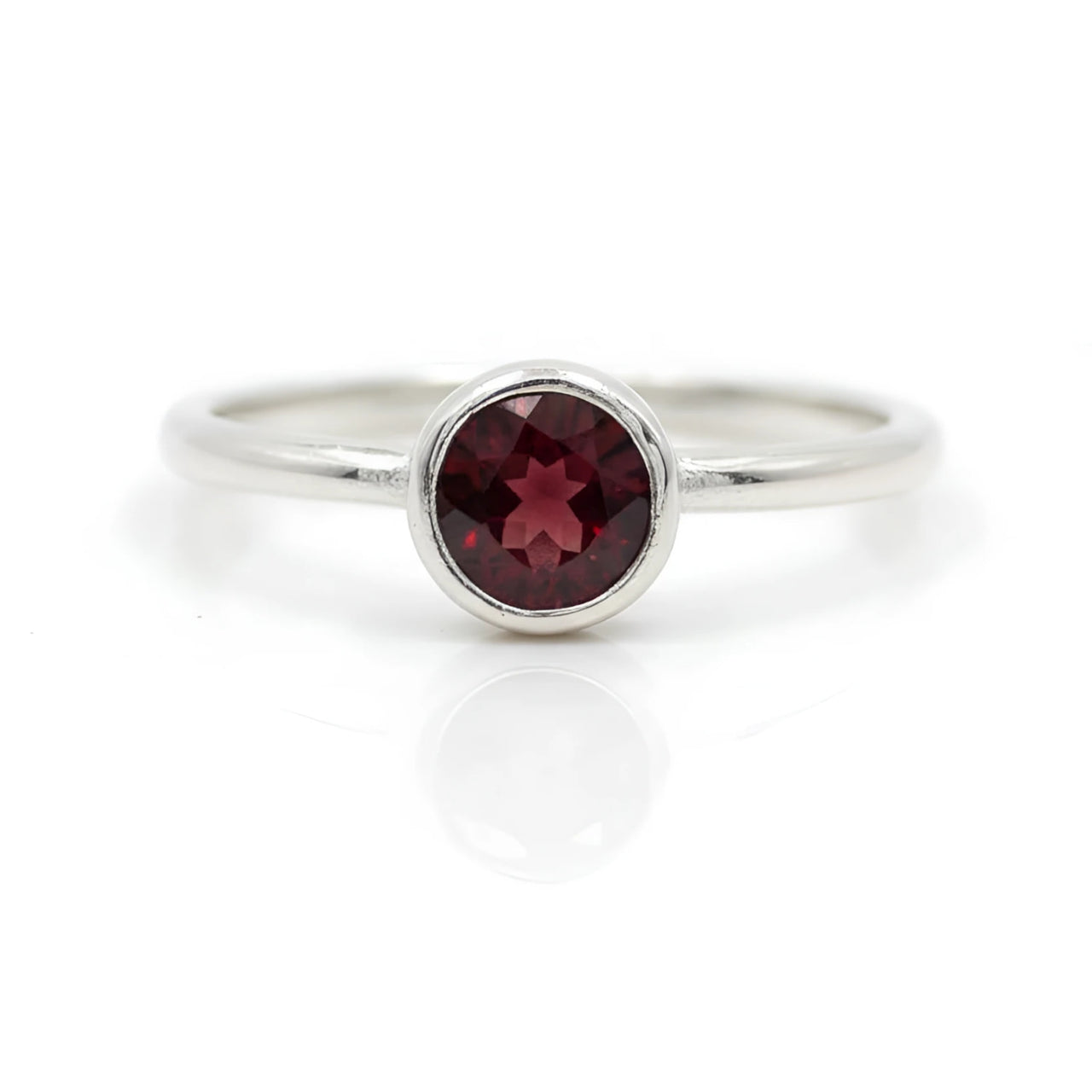 Sleek silver band ring with round-cut garnet in minimalist bezel, BC0408