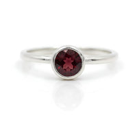 Sleek silver band ring with round-cut garnet in minimalist bezel, BC0408