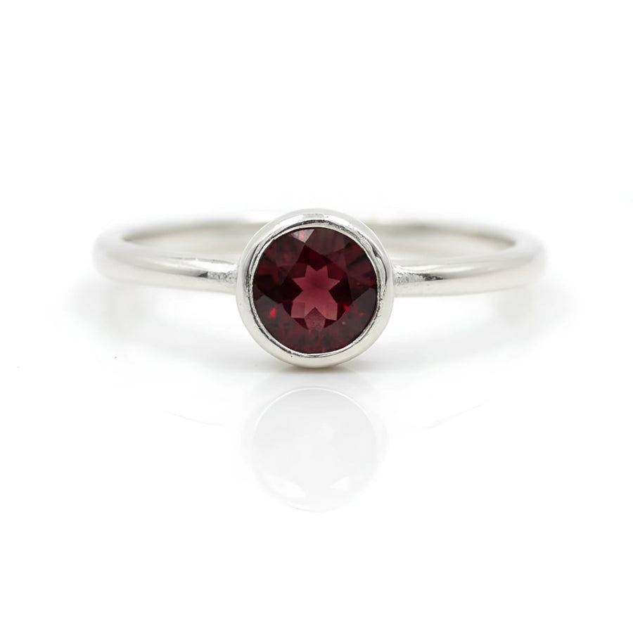 Sleek silver band ring with round-cut garnet in minimalist bezel, BC0408
