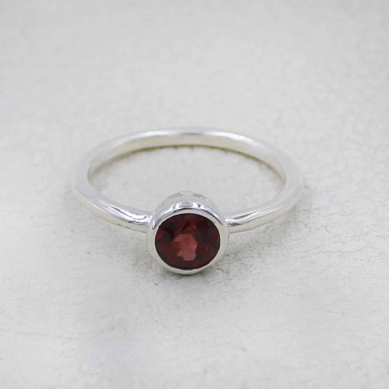 Delicate sterling silver band ring with faceted garnet in bezel #BC0408