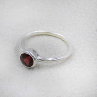 Delicate sterling silver band ring with round-cut garnet in bezel setting BC0408