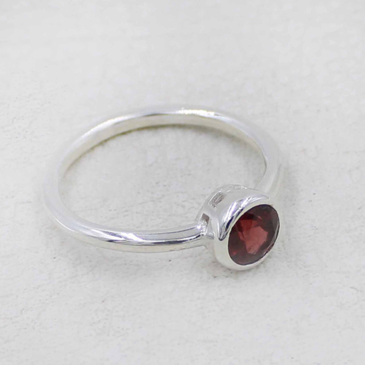 Sleek sterling silver band ring with round-cut garnet in minimalist bezel #BC0408