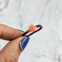 Thumbnail for Hand holding a flower-shaped beaded ring named Garnet Flower 1’ Beaded Stretchy Ring #LV1971