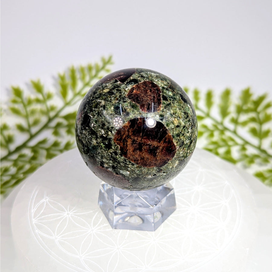 Polished green brown garnet schist 1.75 inch sphere BC0887 on acrylic stand