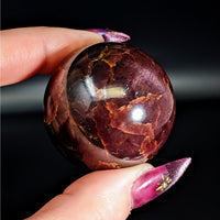 Thumbnail for Person holding the Garnet Sphere #LV4575, a large and vibrant purple stone