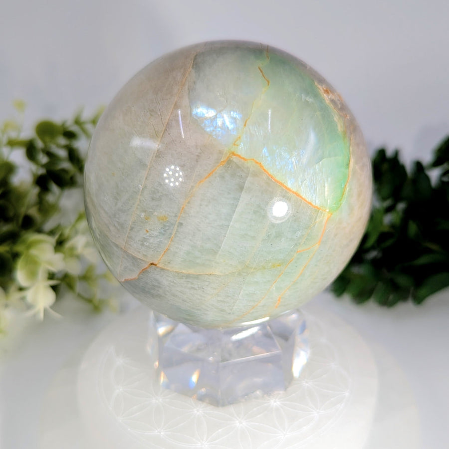 Garnierite 3.3 inch sphere made of translucent green and white aventurine crystal with golden veining on clear stand