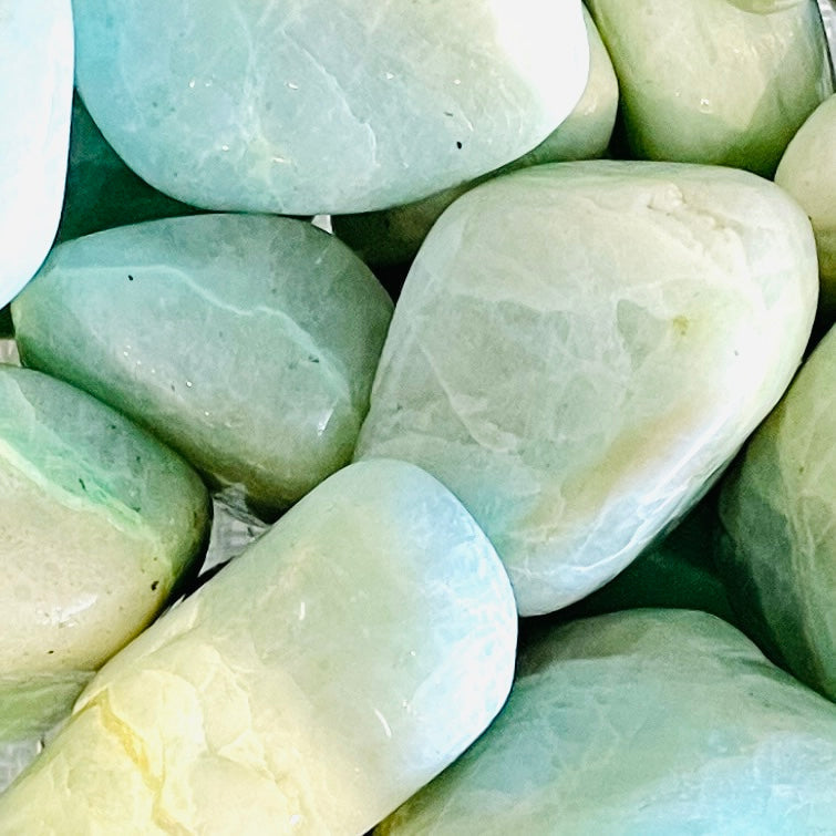 Smooth, polished garnierite tumbled stones with a jade-green translucent appearance