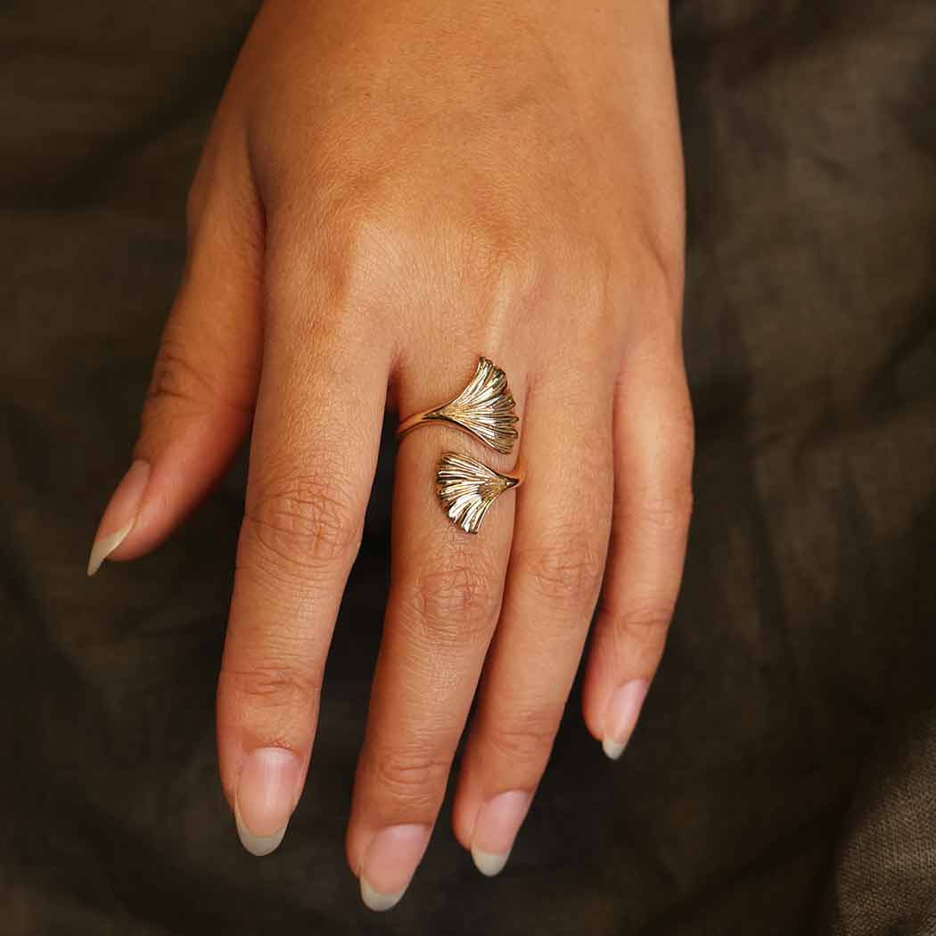 Close-up of a woman’s hand wearing a Ginkgo Leaf Adj. Bronze Ring #J014 with a gold finish