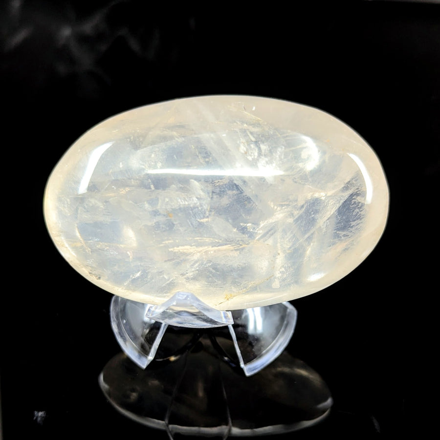 A translucent oval-shaped milky white girasol quartz 3.2 inch jumbo pebble with visible internal crystalline patterns