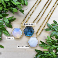 Three faceted hexagonal gemstone pendants on gold box chains: labradorite, opalite, moonstone