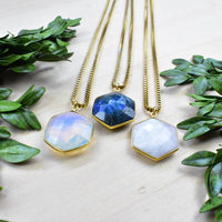 Three gold faceted hexagonal labradorite necklaces with iridescent blue hues