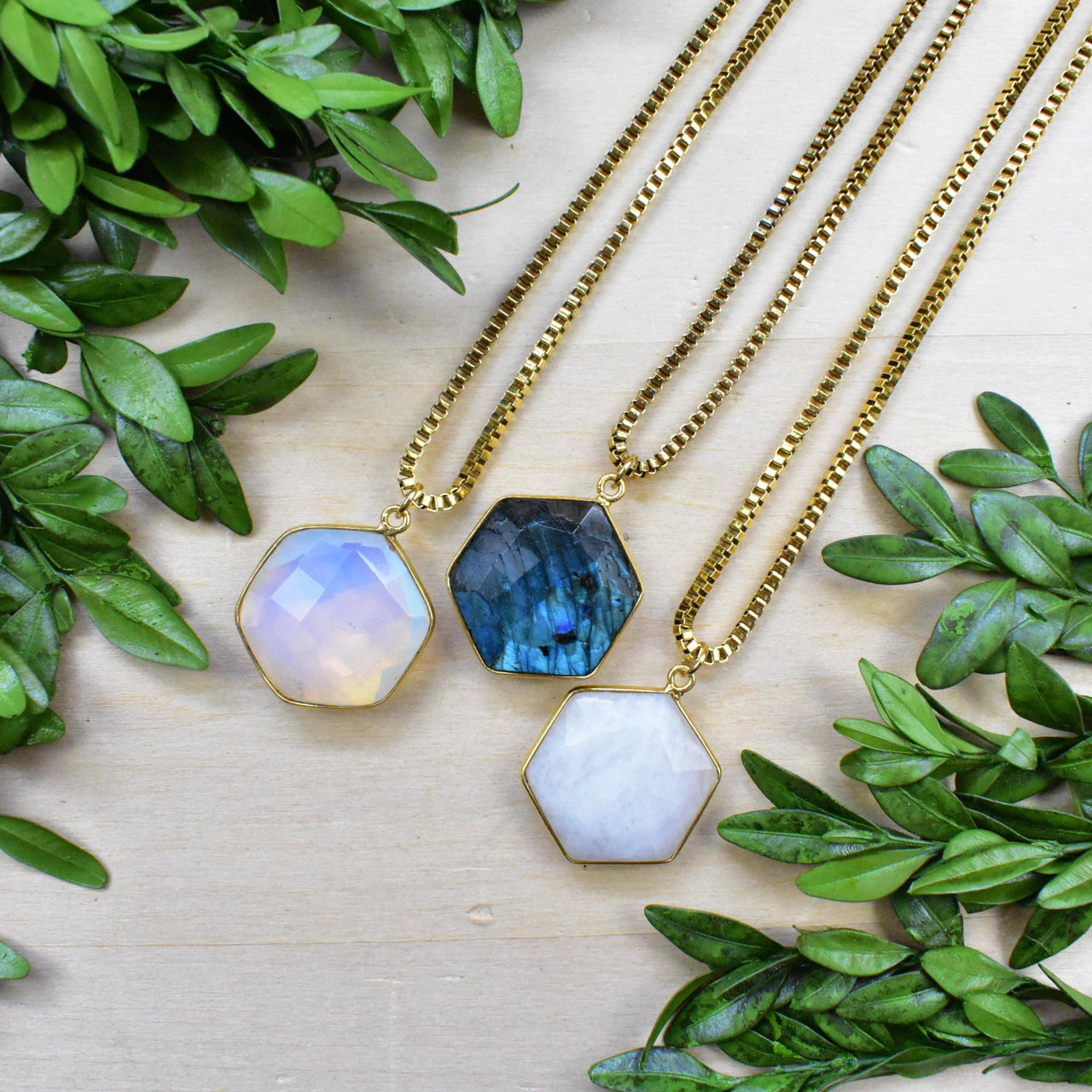 Three gold faceted hexagon labradorite opal necklaces in blue, white, lavender