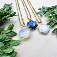 Three gold faceted hexagon gemstone necklaces in blue, opal white, translucent