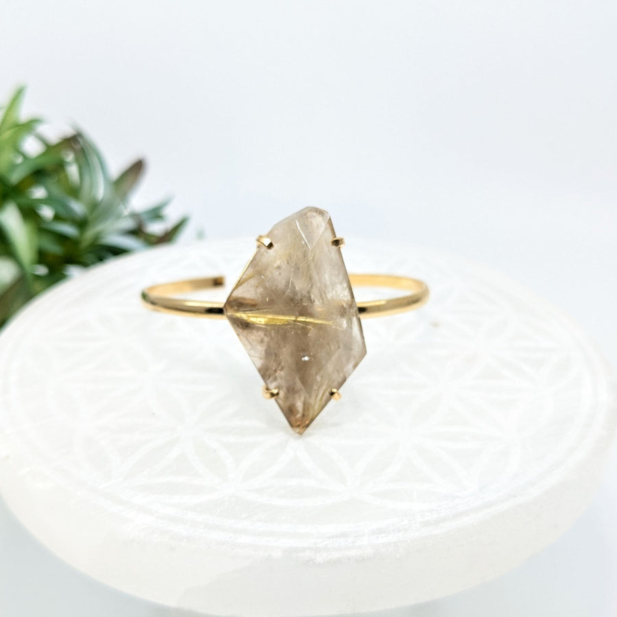 Gold rutilated quartz simple cuff bracelet featuring a smoky quartz crystal