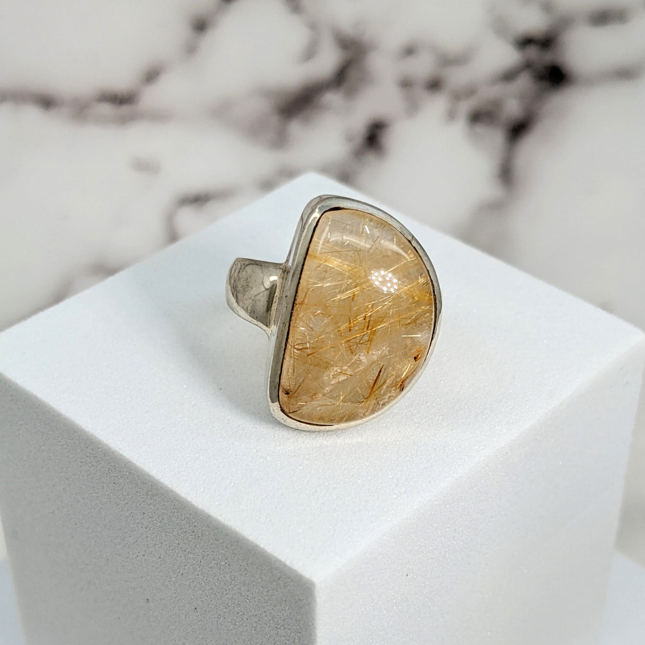 Gold Rutile Sz 7.5 Half Moon SS Ring #SK9529: Yellow Quartz on White Marble Block