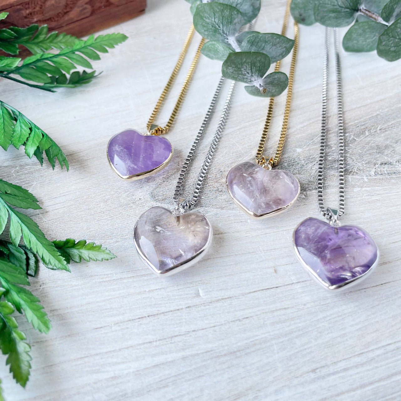 Three amethyst heart pendants with silver and gold chains, LV9397