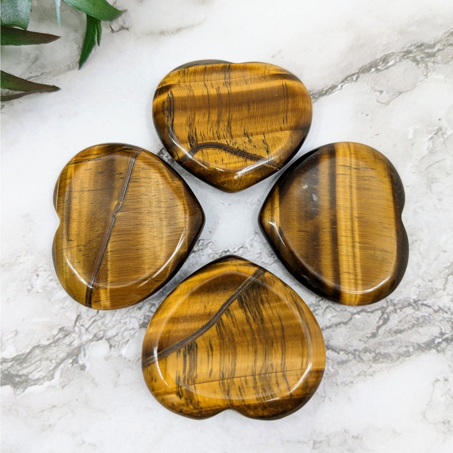 Four heart-shaped Tiger’s Eye stones in a Gold 1.5-inch thumb stone display