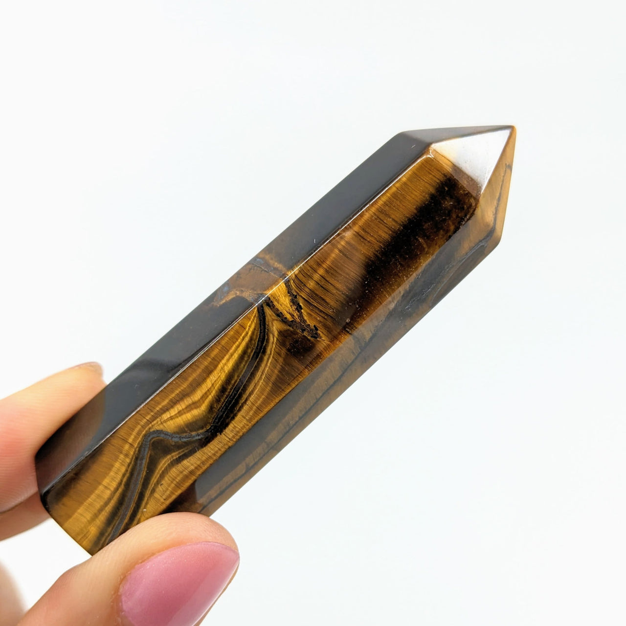 A hand holding a piece of Gold Tiger’s Eye 3’ Generator #LV2724 tigers eye crystal