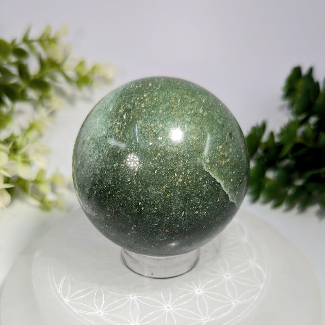 Green aventurine 2.4 inch polished sphere with golden flecks displayed on a clear acrylic stand
