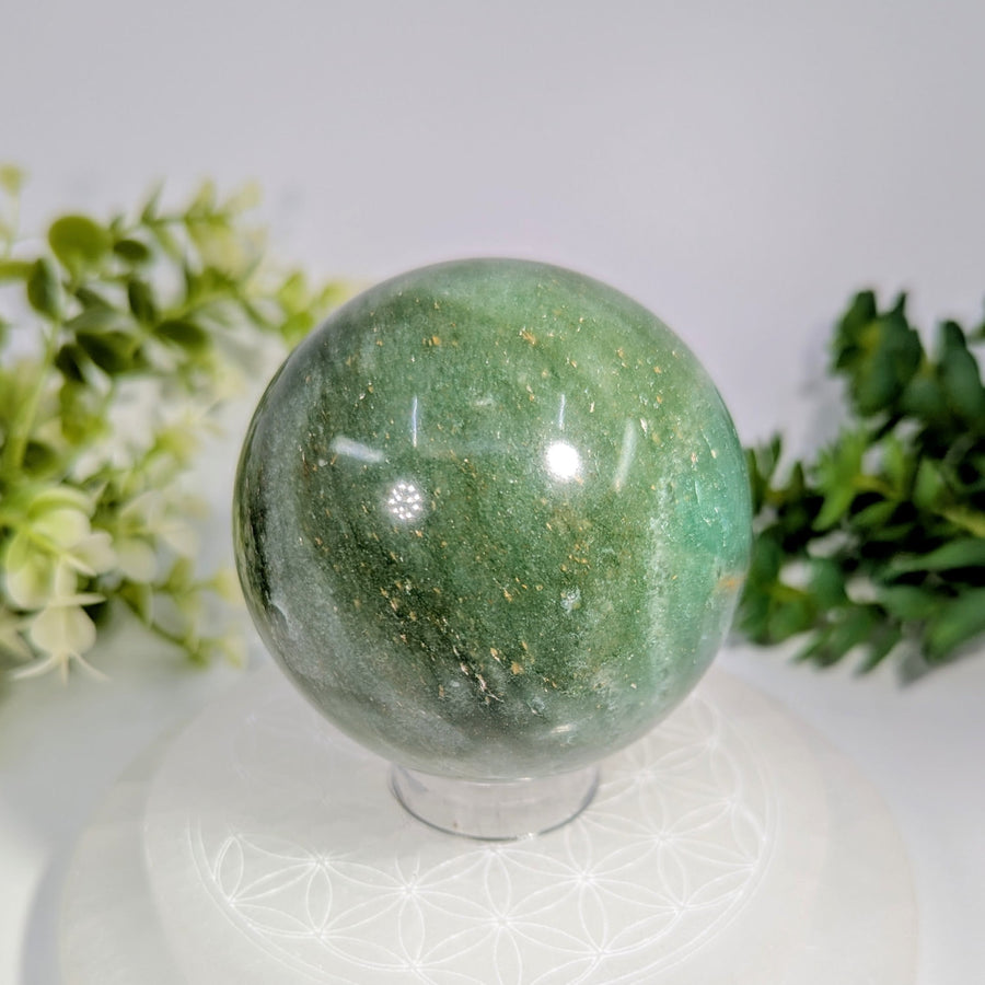 Green aventurine 2.7 inch polished sphere with golden flecks displayed on a clear acrylic stand