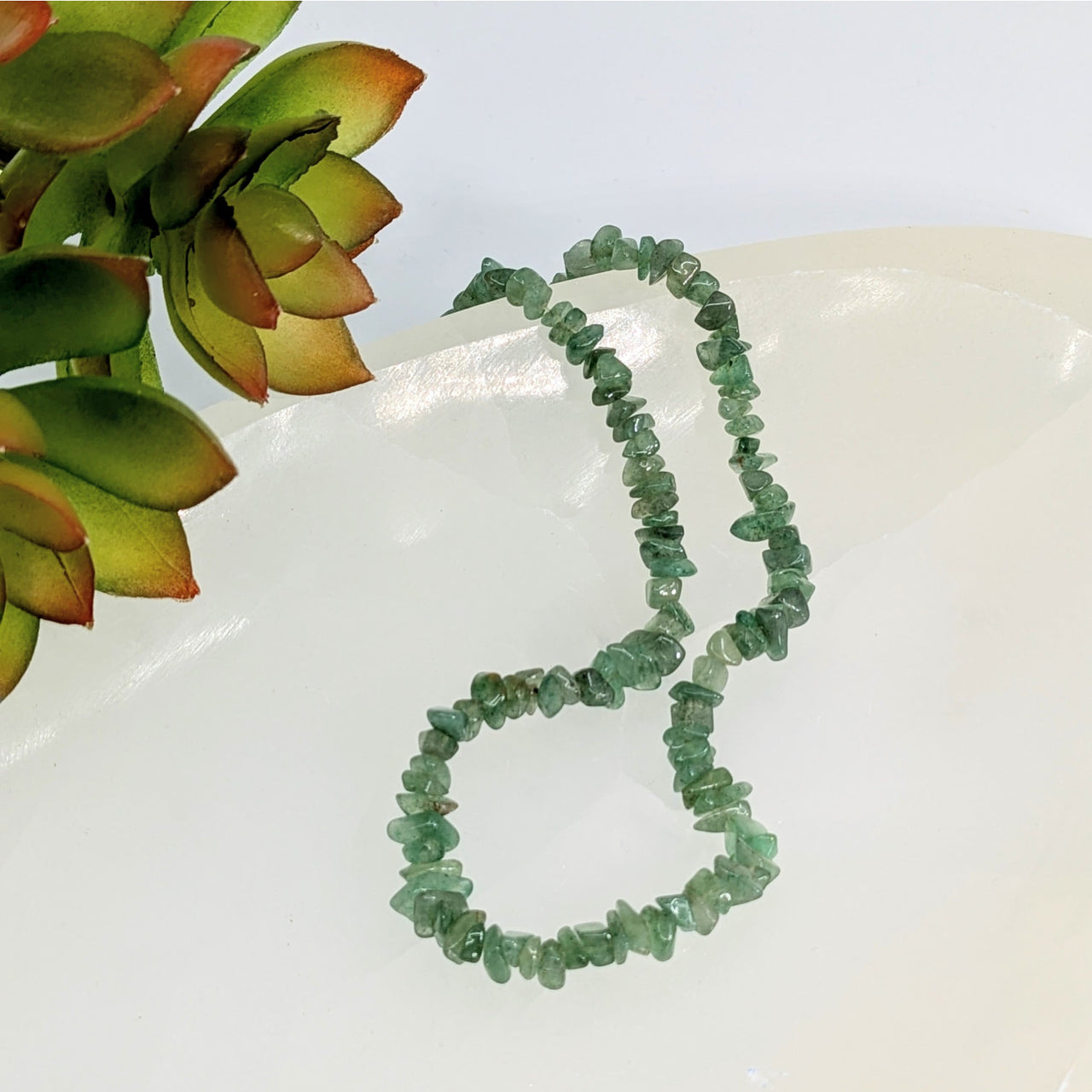 Green Aventurine 3mm chip beads necklace arranged in a curved line for jewelry making