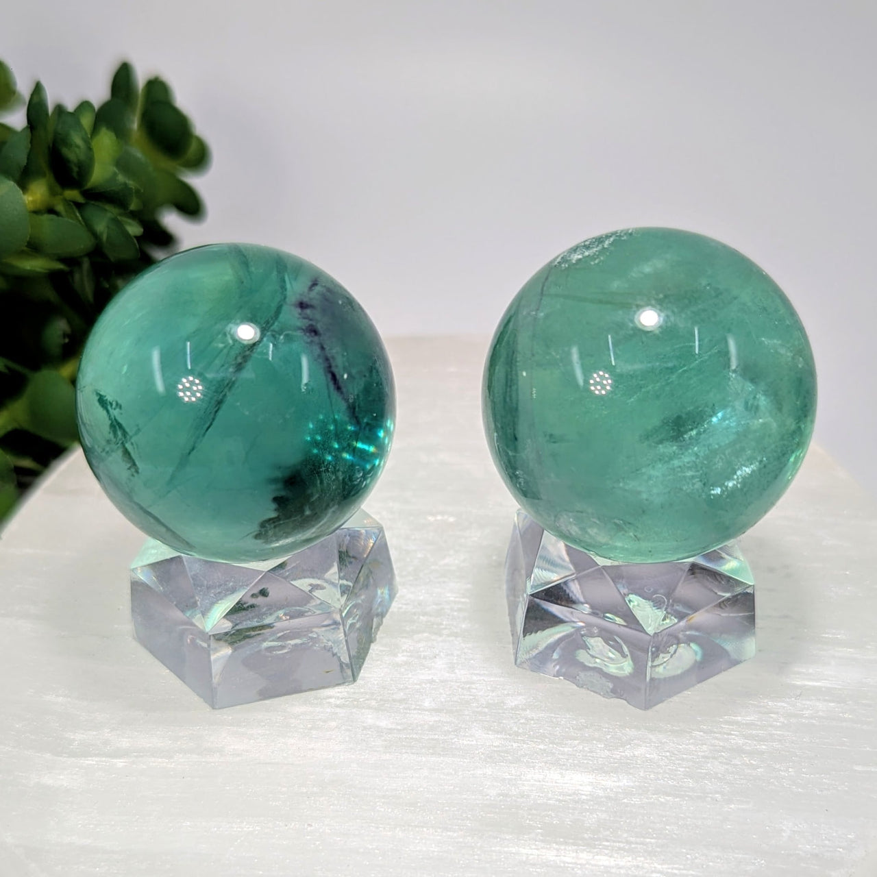 Two polished green fluorite spheres on clear bases, 1.3-1.5 inch