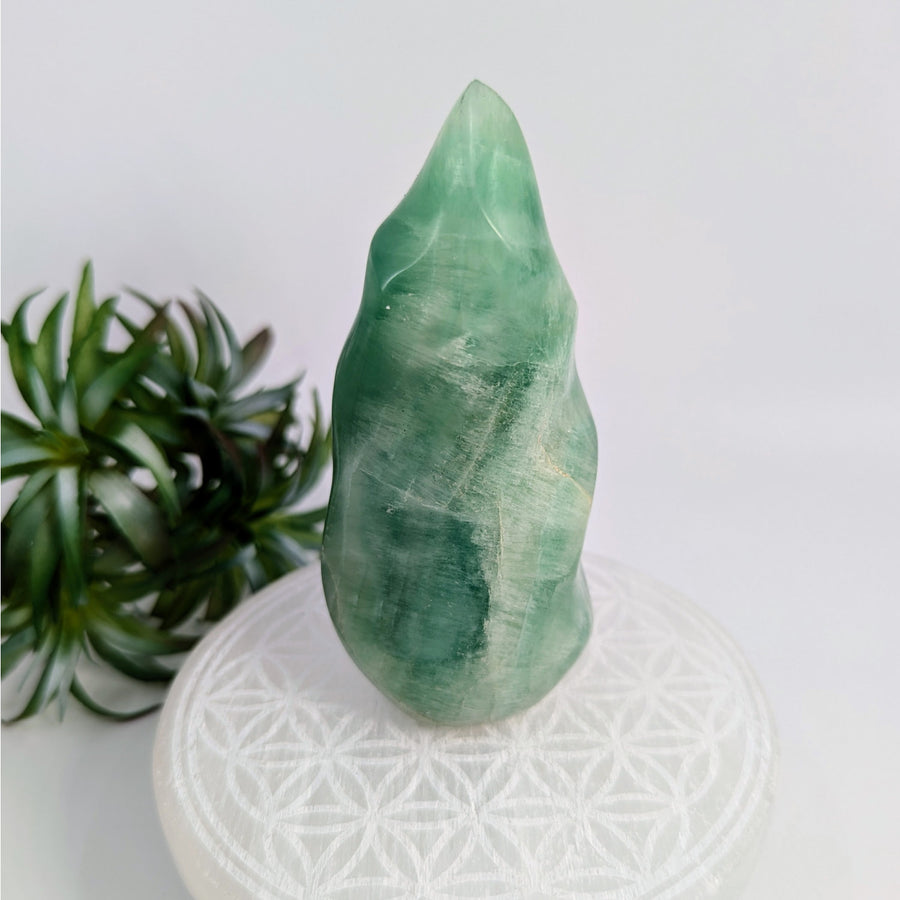 Green fluorite flame carving showcasing protective stones and bliss crystals design