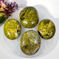 Four polished green opal pebbles, 2-2.5 inches, speckled yellow, glossy surface