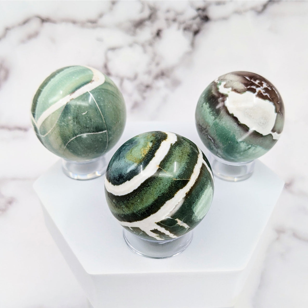 Green Sardonyx Sphere #S065: Three marble spheres on a marble pedestal