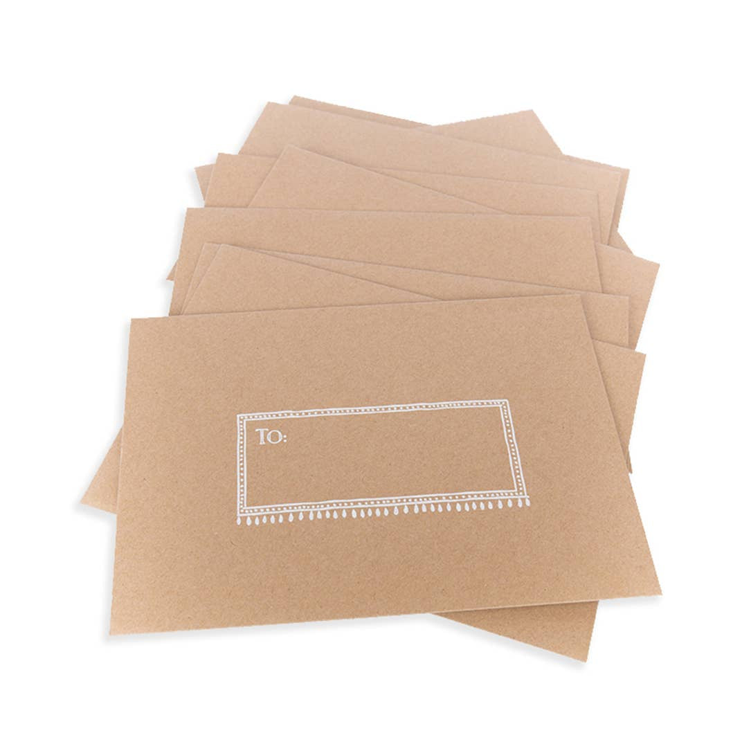 Stack of kraft paper envelopes with decorative address labels for Eye Wish Birthday card