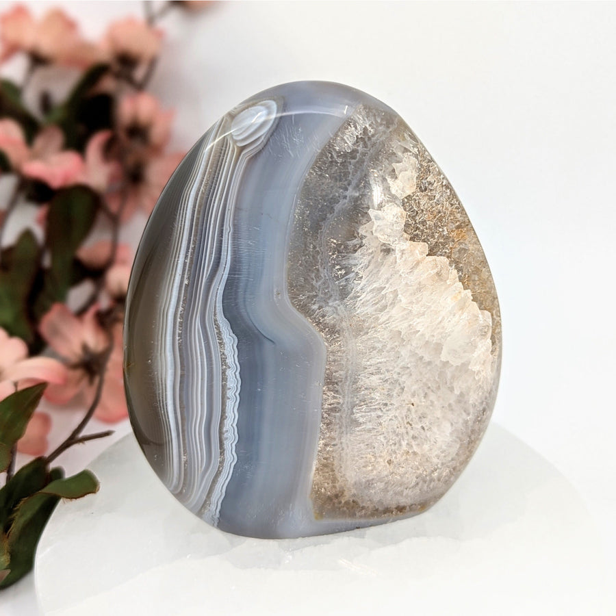 Polished Grey Banded Agate Geode with crystalline interior and banded gray exterior