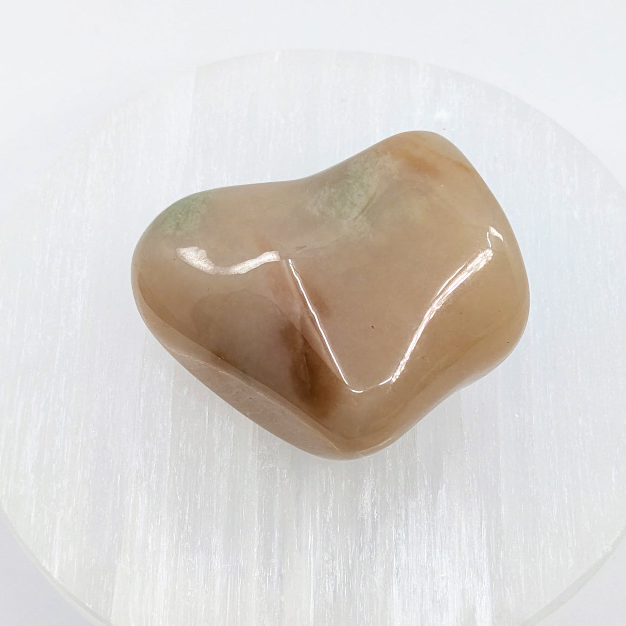 Heart-shaped Grossularite Garnet pebble in pink and green on white background