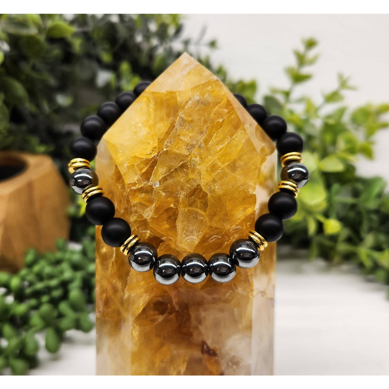Black beaded bracelet with gold accents, hematite beads, and citrine stand
