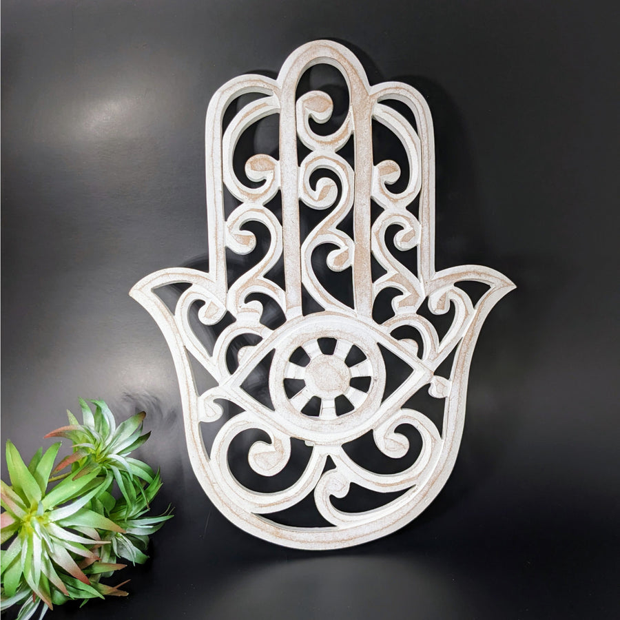 Hamsa 11.5’ Wood Wall Hanging #LV4159, close up of white hamsa hand with plant background