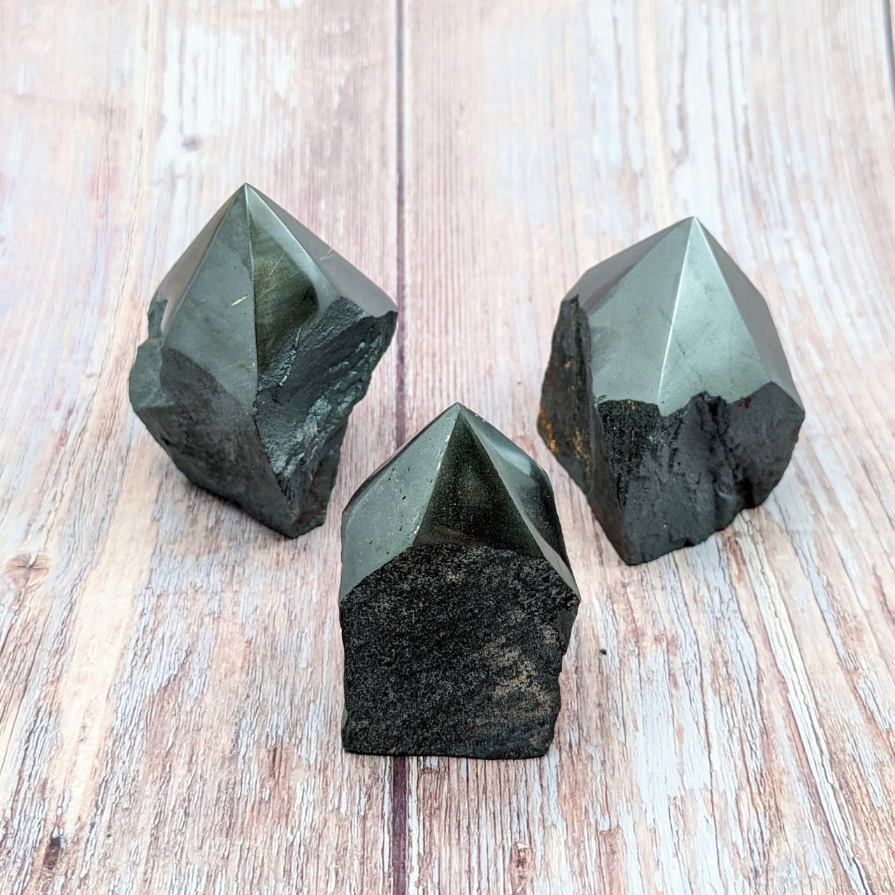 Green quartz crystals on wooden surface - Hematite Rough 2.5-3’ Point #SK9982