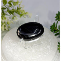 Hypersthene 1.8 inch palm stone with a smooth polished black surface and glossy finish with subtle internal striations