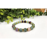 Green aventurine bracelet with gold accents, purple beads, and rose quartz center