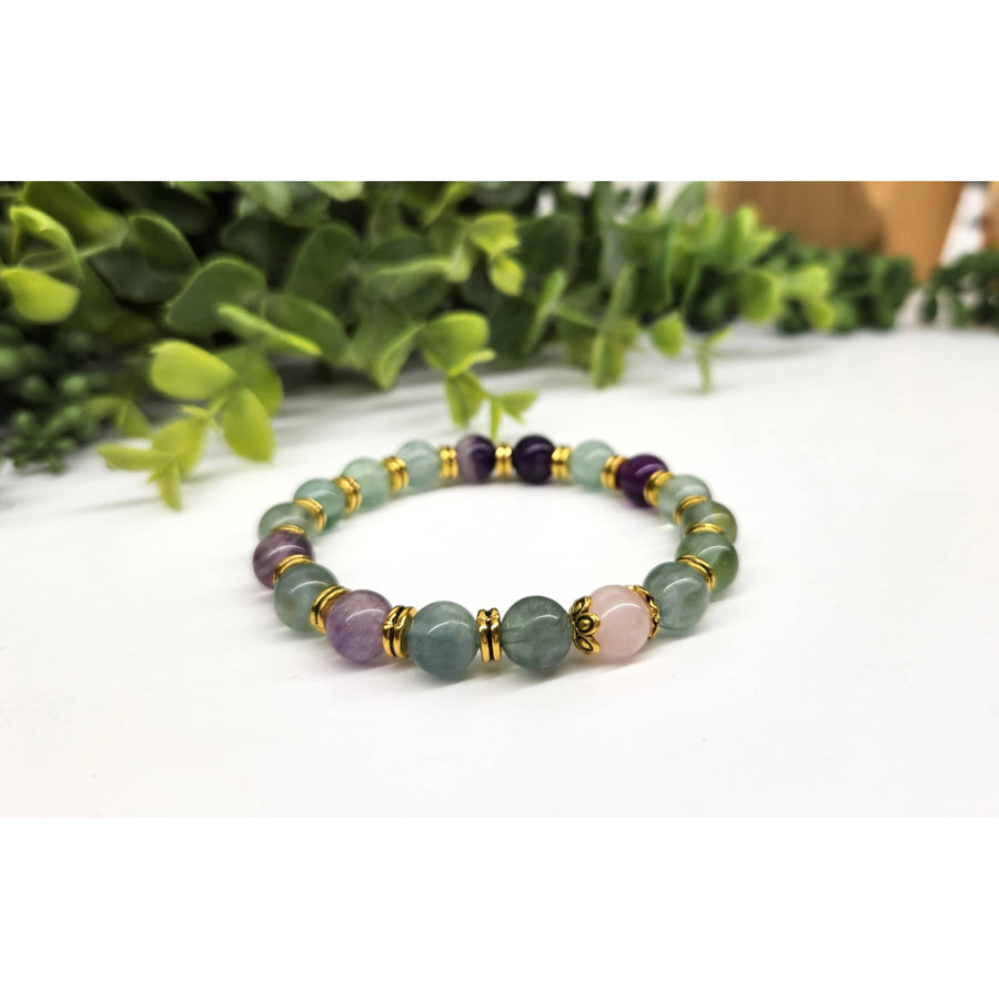 Green aventurine bracelet with gold accents, purple beads, and rose quartz center
