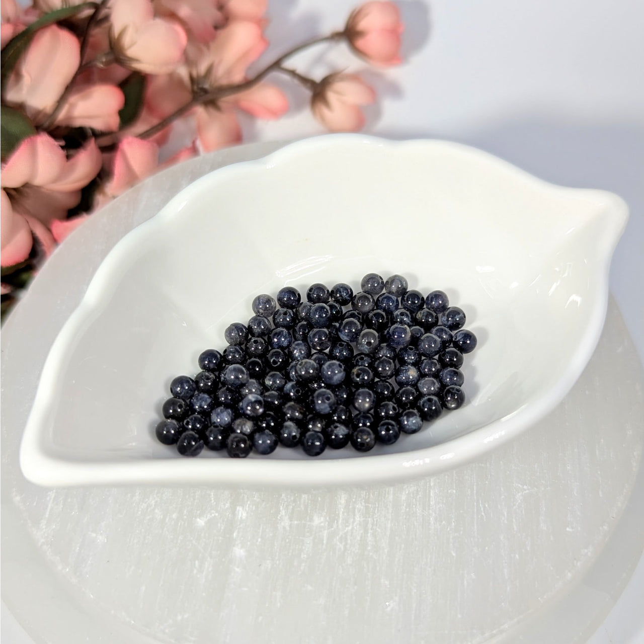 Iolite 4mm round beads with blue-gray sheen in leaf dish