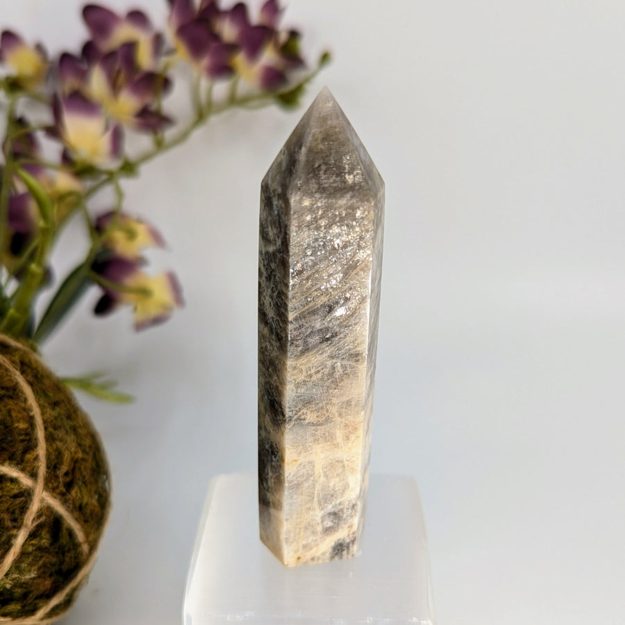 Polished crystal point with gray and tan striations in the Irridescent Sunfire Moonstone Tower