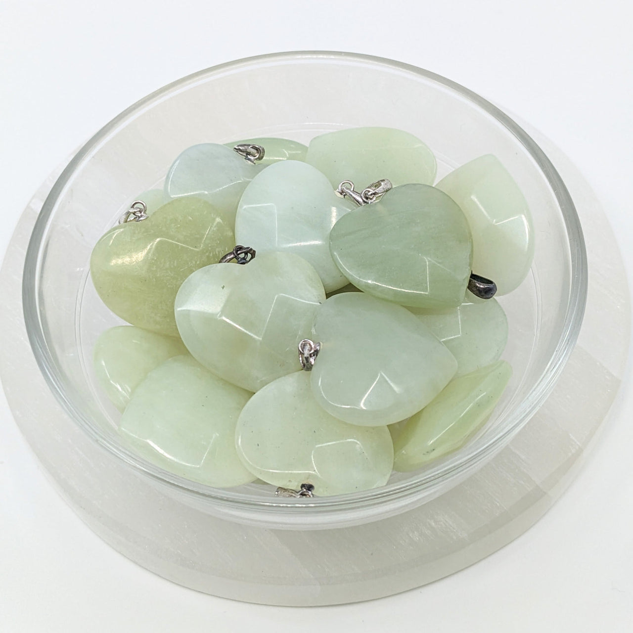 Jade Green Faceted 1’ Heart Pendant #LV1856 with a bowl of green jade pebbles in the background