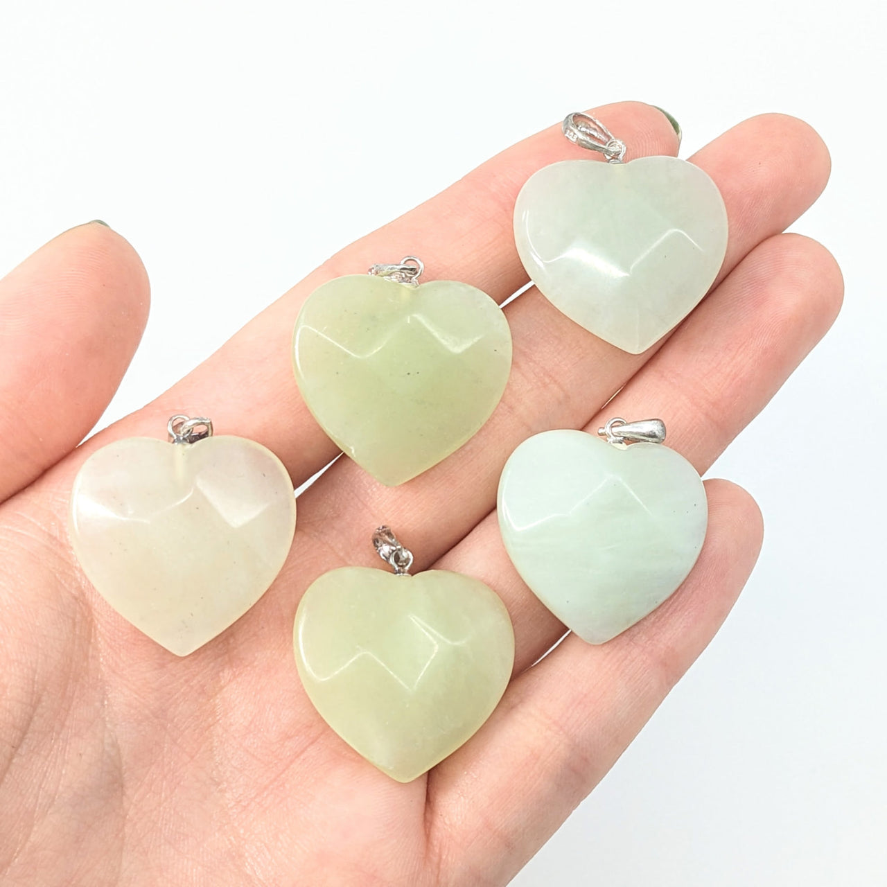 Hand holding Jade Green Faceted Heart Pendants, product Jade Green Faceted 1’ Pendant #LV1856