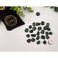 Green malachite rune stone set with gold inscriptions in black bag