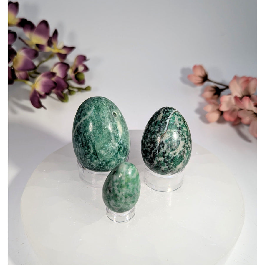 Three polished green jade yoni eggs with hole, 1-2 inches, marbled patterns